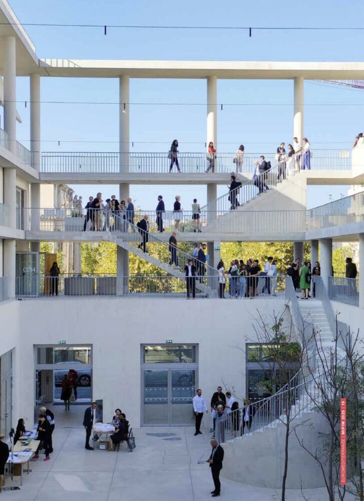 The vertical public space that links stacked communal areas and terraces, encouraging informal encounters between the seven schools housed within. Courtesy of the architects.